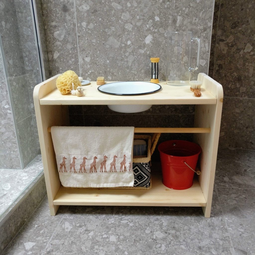 Organized setup with enamel bucket, jug, and toiletries on the washing station shelf.