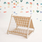 Wooden pikler climbing structure with a white base on a light background