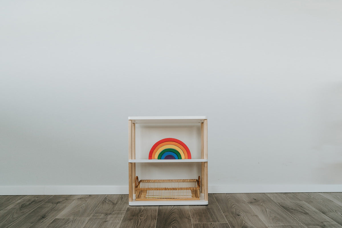 Straight Mini shelf with three white shelves and natural wood sides, styled with a rainbow toy and wicker basket.